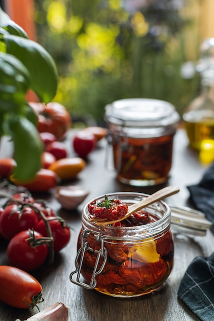 Italiaanse keuken, gedroogde tomaten in glazen pot met aromatische kruiden