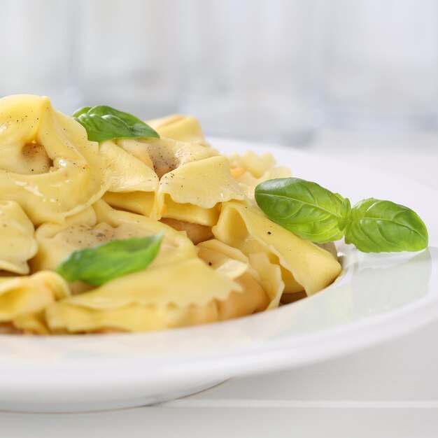 Foto italiaanse keuken tortellini pasta noedels maaltijd met basilicum