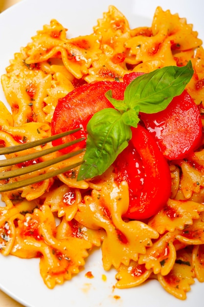 Foto italiaanse pasta farfalle vlinderbootje en tomatensaus