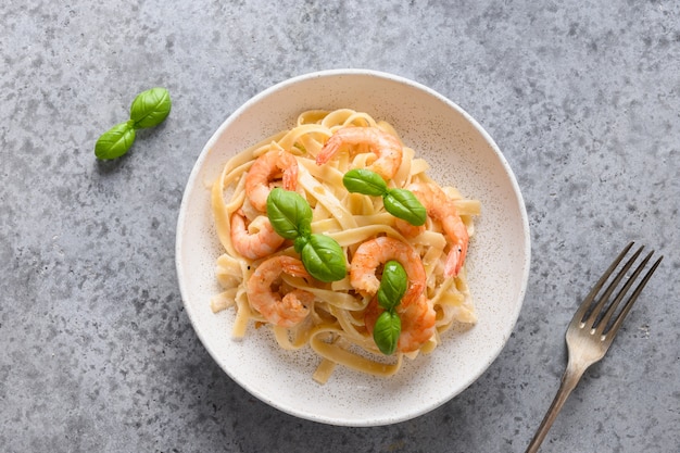 Italiaanse pasta fettuccine met garnalen op grijze tafel. bovenaanzicht.