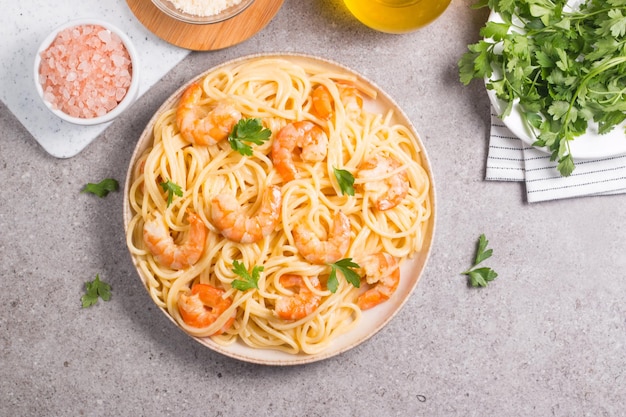 Italiaanse pasta fettuccine of spaghetti in een romige kaassaus met garnalen of gamba's op een bord
