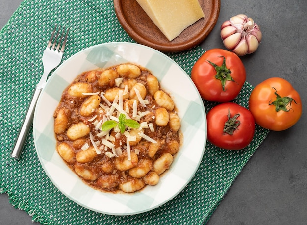 Italiaanse pasta gnocchi op een bord met tomatensaus, basilicum en Parmezaanse kaas.