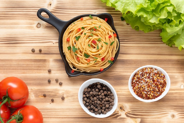 Italiaanse pasta in een koekenpan op een lichte houten ondergrond