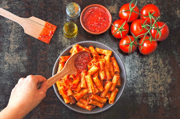 Italiaanse pasta in een kom met verse tomatensaus. Veganistische kom met pasta in tomatensaus.