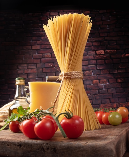 Italiaanse pasta (macaroni), tomaten, olijfolie, kaas en kruiden op rustiek hout