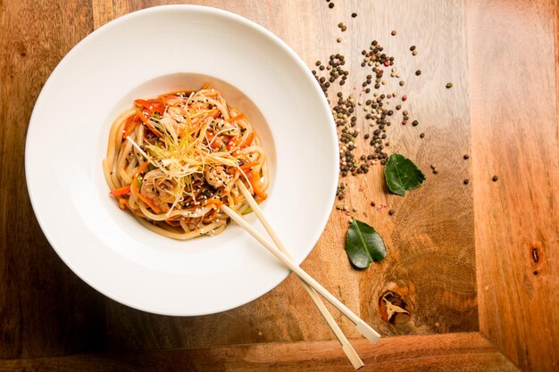 Foto italiaanse pasta met parmezaanse kaas en romige saus en spek. spaghetti in een bord met kruiden. detailopname. concept - voedsel, delicatessen.