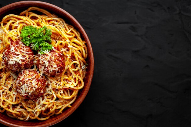 Italiaanse pasta met tomatensaus en gehaktballen in een plaat op een stenen achtergrond