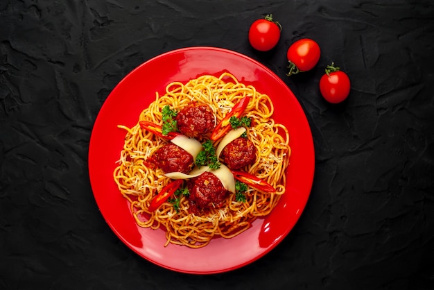 Italiaanse pasta met tomatensaus en gehaktballen in een plaat op een stenen achtergrond