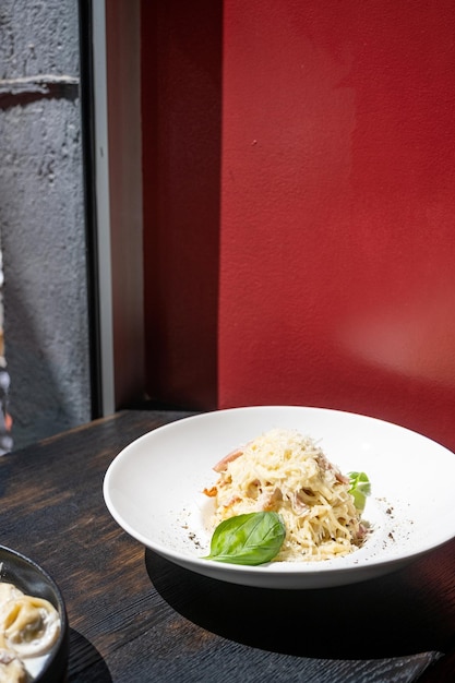 Italiaanse pasta op zwarte café-teller naast het raam tijdens de lunch