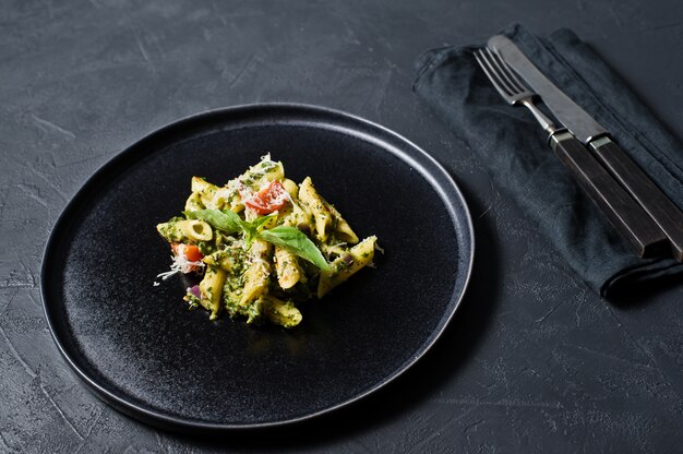 Italiaanse pasta Penne met spinazie, cherrytomaatjes en basilicum. Ingrediënten voor het koken.