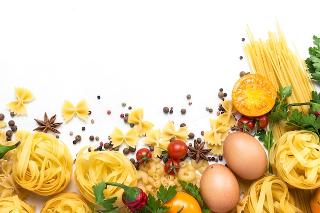 Italiaanse pasta van verschillende soorten met kruiden, rode peper, kippeneieren op een witte achtergrond.