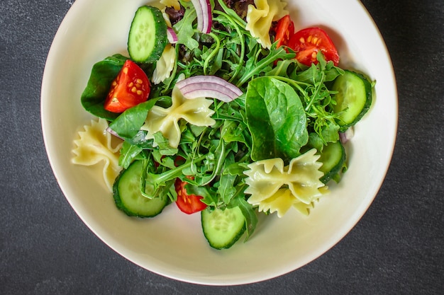 Italiaanse pastasalade farfalle, groenten, mixbladeren, bovenaanzicht
