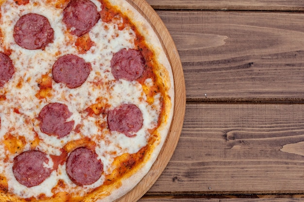 Italiaanse Pepperoni-pizza met salami op donker hout, bovenaanzicht. Italiaanse traditionele gerechten.
