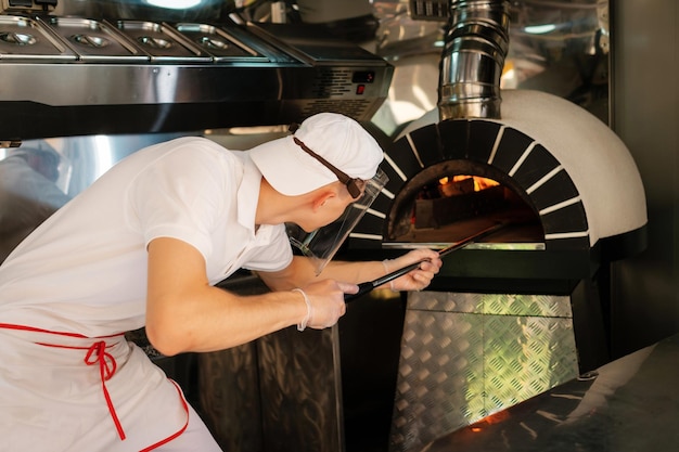 Italiaanse pizza houtkachel Italiaanse pizza wordt gekookt in een houtgestookte oven