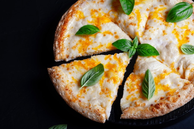 Italiaanse pizza Margherita met kaas en basilicum op zwart betonnen tafelblad uitzicht