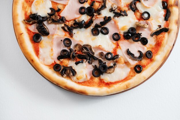 Italiaanse pizza met ham, olijven en kaas Ruimte kopiëren