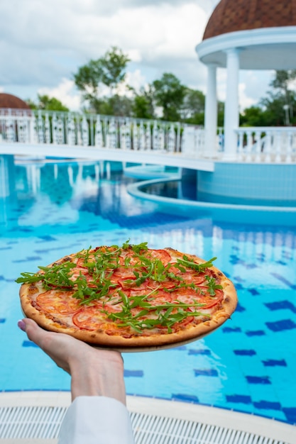 Italiaanse pizza met kruiden op een houten tafel