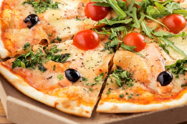 Foto italiaanse pizza met zalm, cherrytomaatjes, rucola en kaas