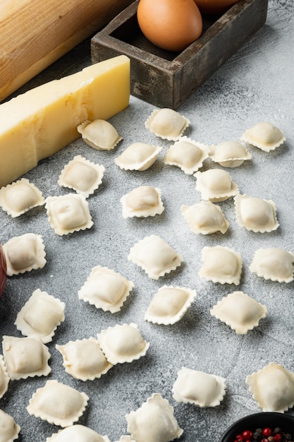 Italiaanse ravioli-ingrediënten met verse ricottabladeren en tomatenset, op grijze achtergrond