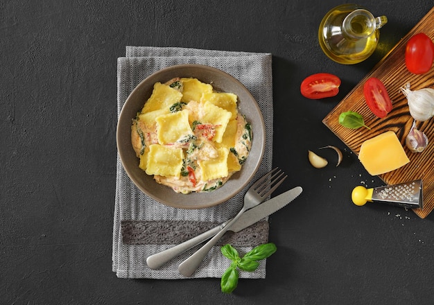 Italiaanse ravioli pasta met kaas en basilicum zwarte achtergrond bovenaanzicht