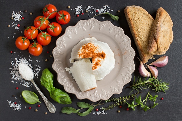 Italiaanse ricotta kaas, zelfgebakken brood, groenten en kruiden bovenaanzicht