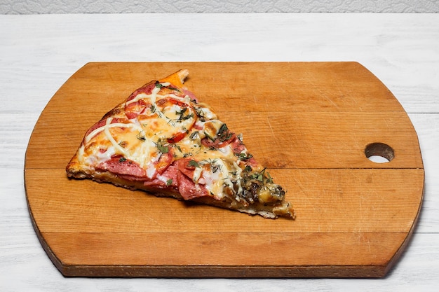 Italiaanse rustieke pizza een stuk op een houten dienblad witte houten tafel