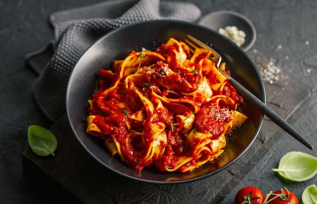 Italiaanse spaghetti met tomatensaus die op plaat wordt gediend