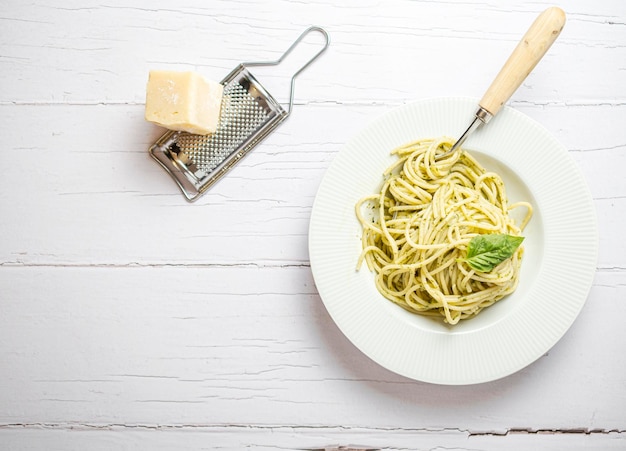 Italiaanse spaghetti met verse huisgemaakte pestosaus Gegeten op een witte houten plank