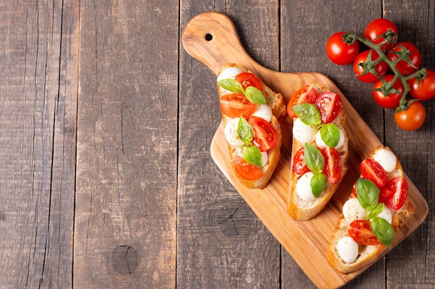 Italiaanse tomaat en kaas bruschetta Tapas antipasti met gehakte groenten kruiden en olie op gegrilde ciabatta en stokbrood