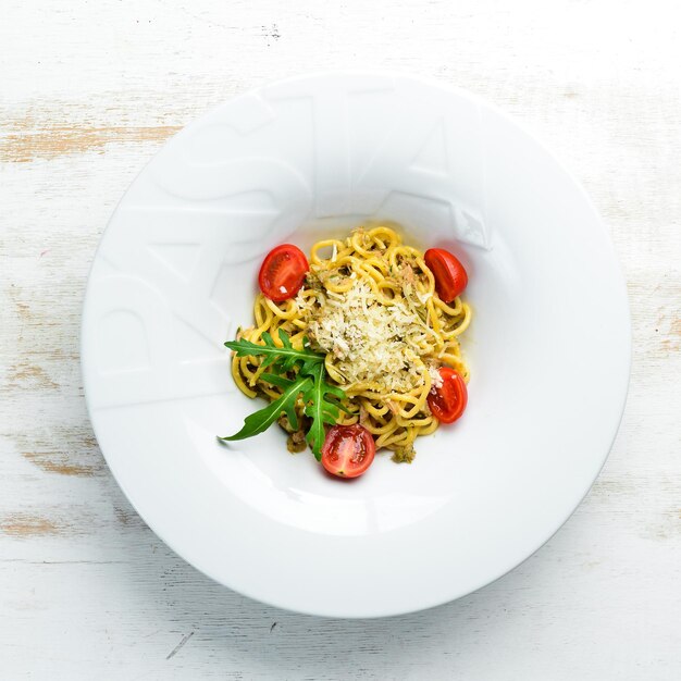 Italiaanse traditionele pasta met tonijn en kerstomaatjes. Bovenaanzicht. Gratis exemplaar ruimte.