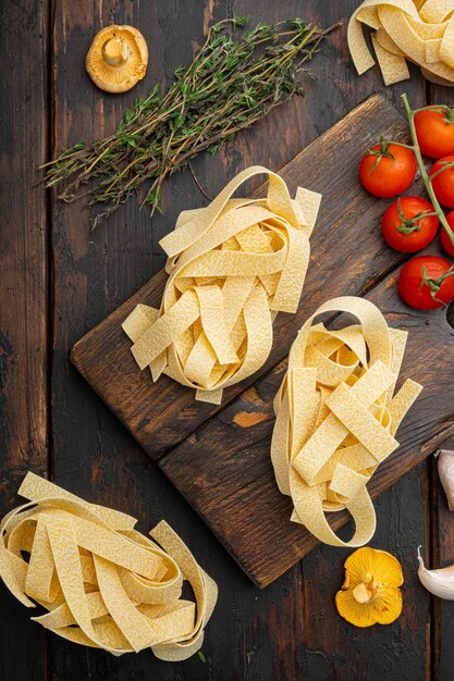 Italiaanse voedselingrediënten pasta set, op oude donkere houten tafel achtergrond, bovenaanzicht plat lag