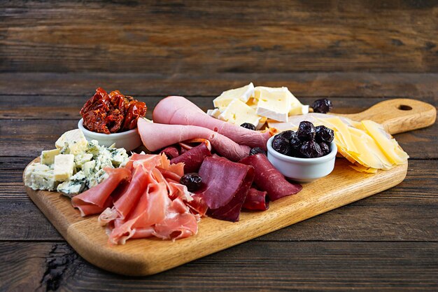 Photo italian antipasto antipasti board with ham salsami prosciutto parmesan blue cheese and olives