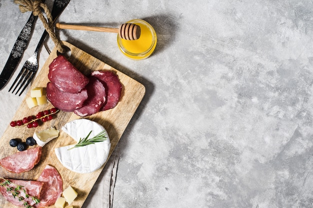 Italian antipasto with prosciutto, salami, Parmesan, brie and Gorgonzola cheese, honey.