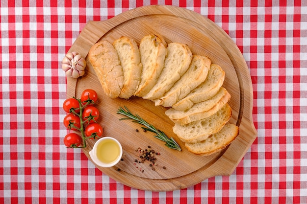 Photo italian appetizer. chiabbata and sliced white bread on wooden boards.