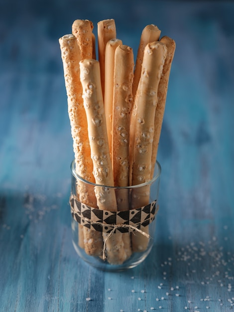 Italian bread sticks in a glass on table with salt