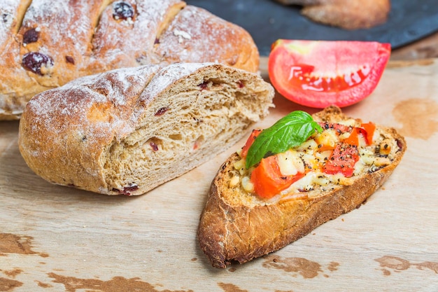 이탈리아 브루체타 는 긴 토마토, 모차라 치즈, 그리고 절단판 에 있는 허브 를 들였다