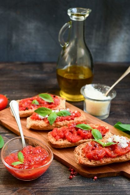Фото Итальянская брускетта с помидорами, оливковым маслом, зеленой петрушкой и розовым перцем.