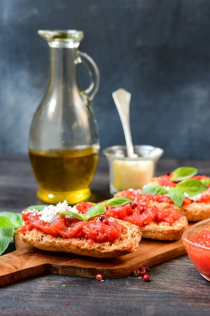 Italian bruschetta with tomatoes, olive oil, green parsley and\
pink pepper.