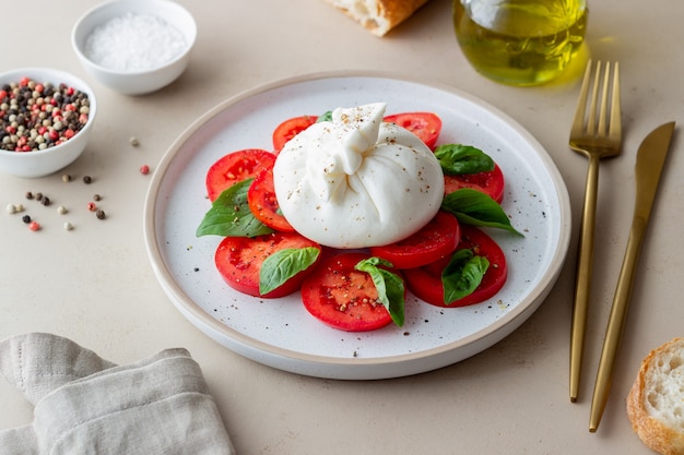 Foto burrata italiana con pomodori e basilico. insalata. mangiare sano. cibo vegetariano.