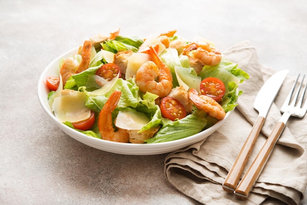 Italian caesar salad with shrimp, croutons and parmesan, selective focus