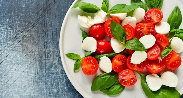 Italian Caprese salad: red tomatoes, mozzarella and Basil, Italian cuisine. Healthy lunch.