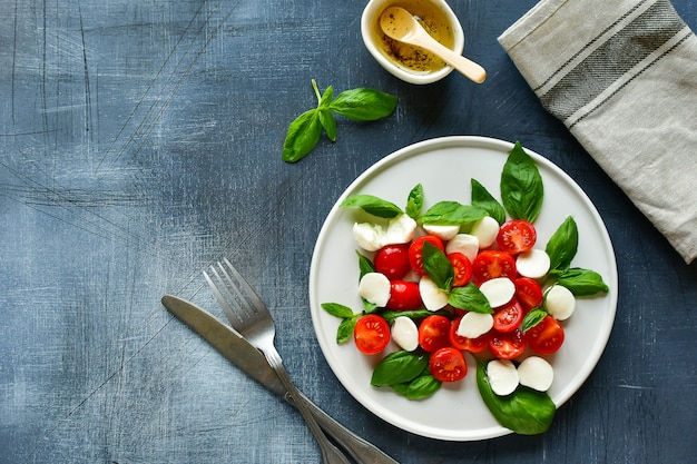 Italian Caprese salad: red tomatoes, mozzarella and Basil, Italian cuisine. Healthy lunch.