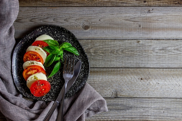 Italian caprese salad with mozzarella and tomatoes. Wooden. Healthy food.