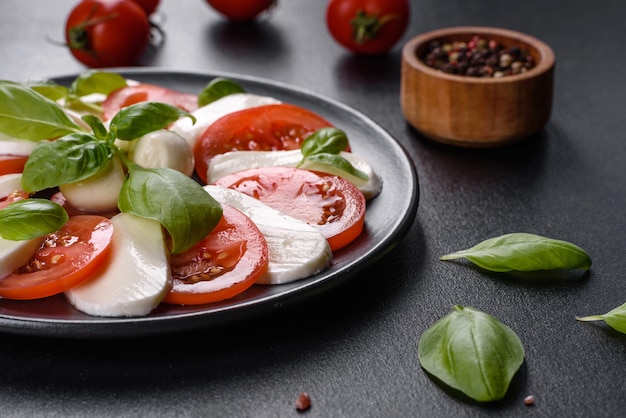 Italian caprese salad with sliced tomatoes, mozzarella cheese, basil, olive oil