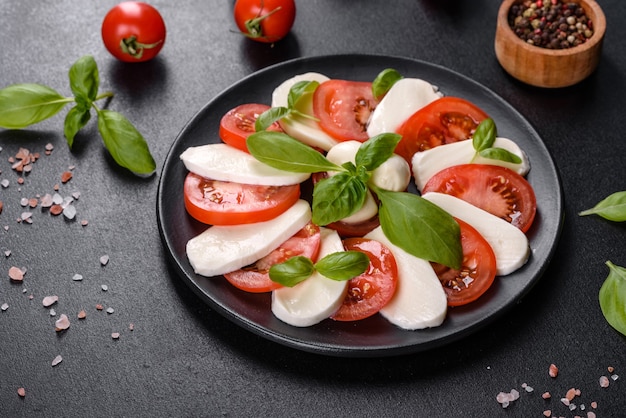 Italian caprese salad with sliced tomatoes, mozzarella cheese, basil, olive oil