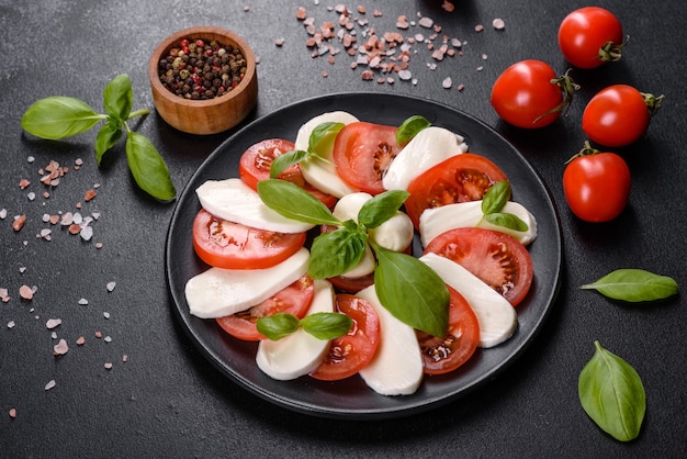 Insalata caprese italiana con pomodori a fette, mozzarella, basilico, olio d'oliva