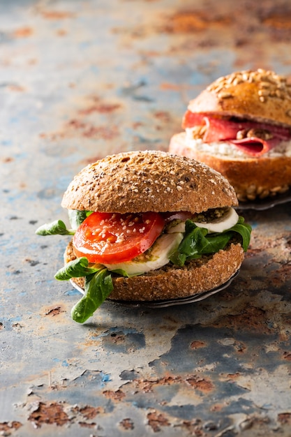 Italian Caprese sandwiches with fresh tomatoes, mozzarella cheese and lamb's lettuce, multigrain bun