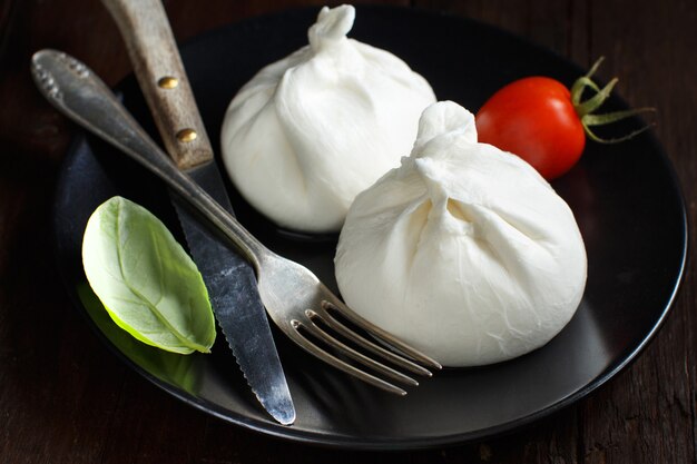 Italian cheese burrata on a plate on a dark background