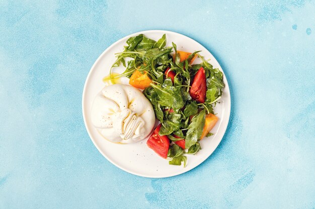 Italian cheese Burrata with fresh arugula, tomatoes, olive oil