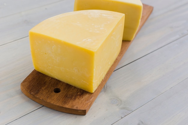 Italian cheese on wooden chopping board over the desk